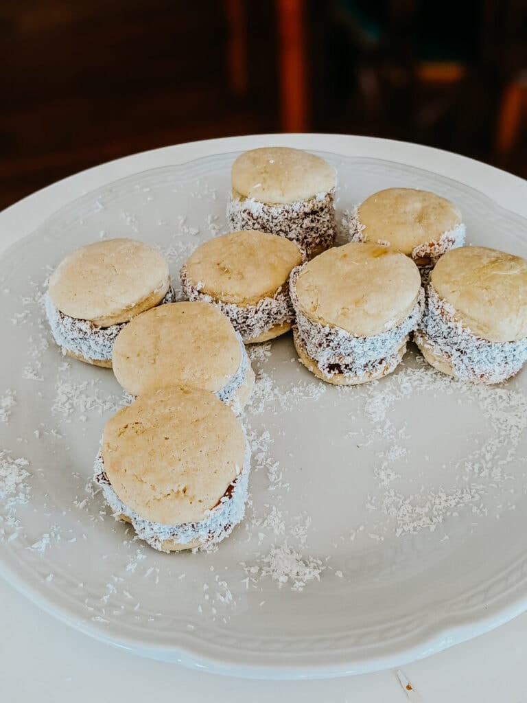 A plate full of alfajor cookies bathed in shaved coconut