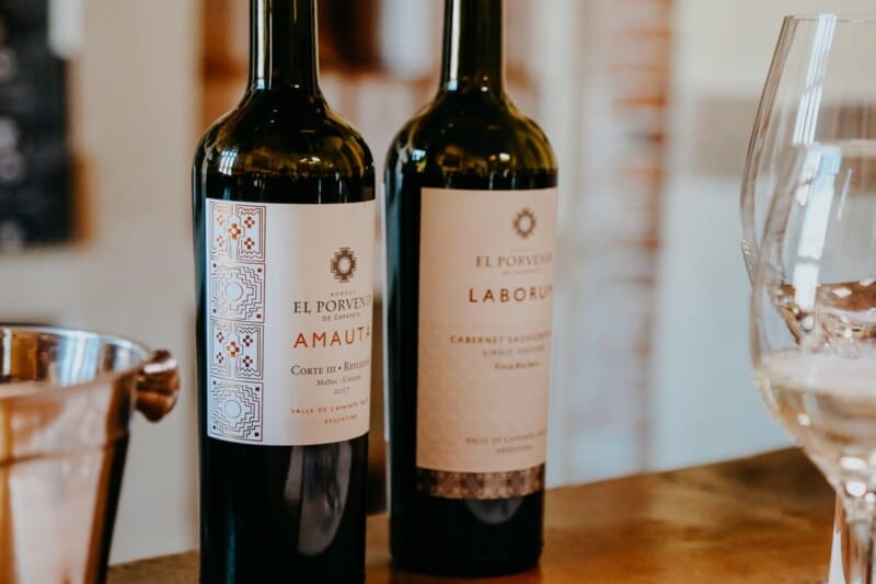 Two bottles of wine and two wine glasses on a bar