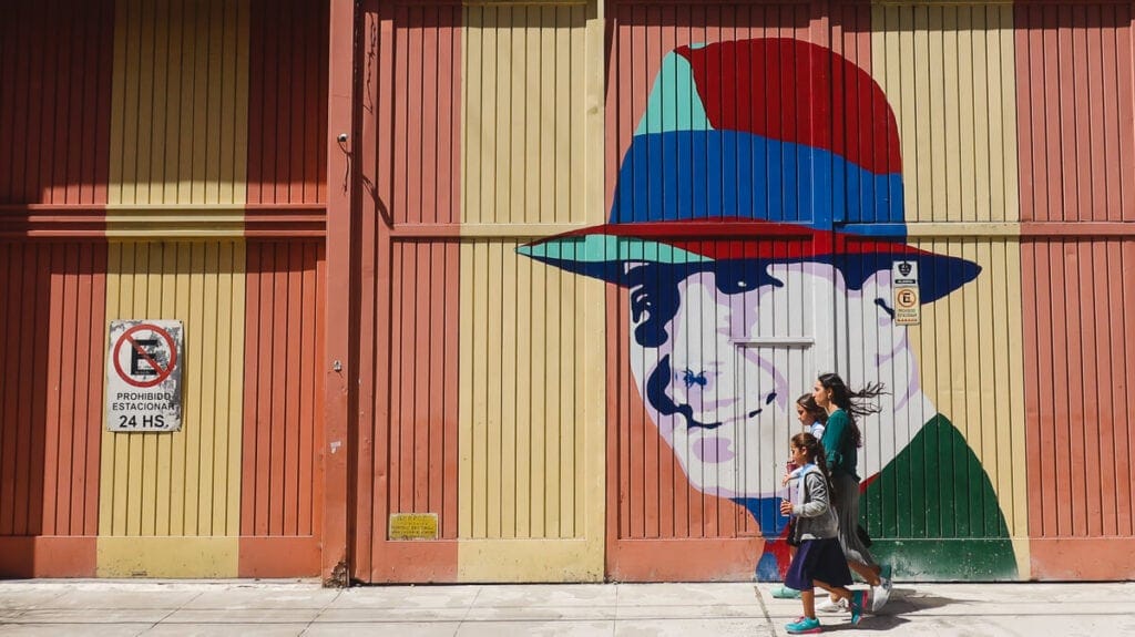 A warehouse painted orange and yellow with a portrait of Carlos Gardel