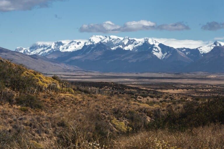 A mountain range in the background behind plains and pasture.