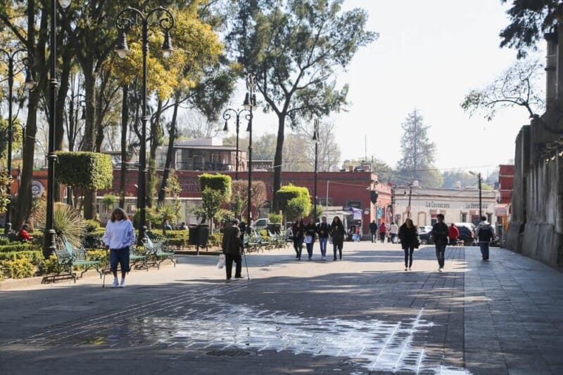 People walking down a sidewalk in a plaza