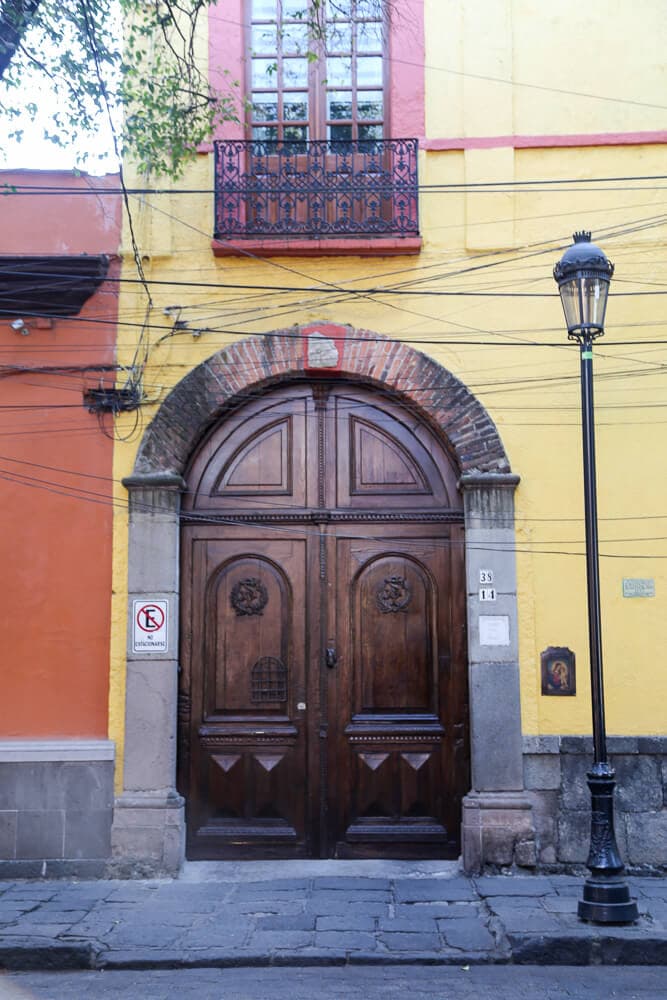 A large wooden door in a yellow home