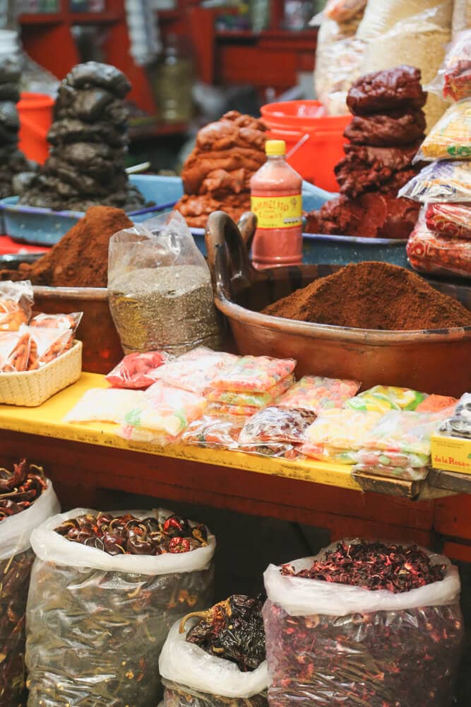 Bags of chili peppers and jars of spices in a market