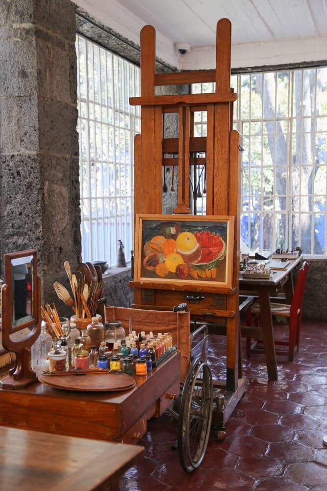 A table with bottles of paint and a still life painting