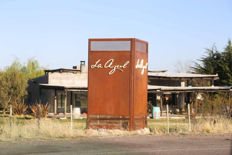 A large metal sign in front of a restaurant