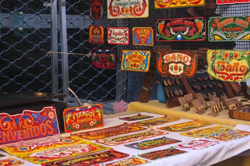 Colorfully painted signs on a table for sale in a Buenos Aires market