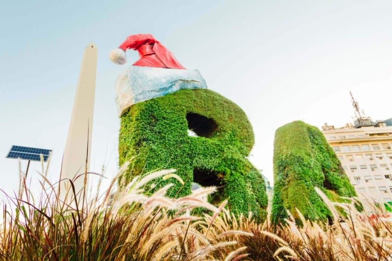 Ivy covered letters B and A with a santa hat on the B in front of an obelisk