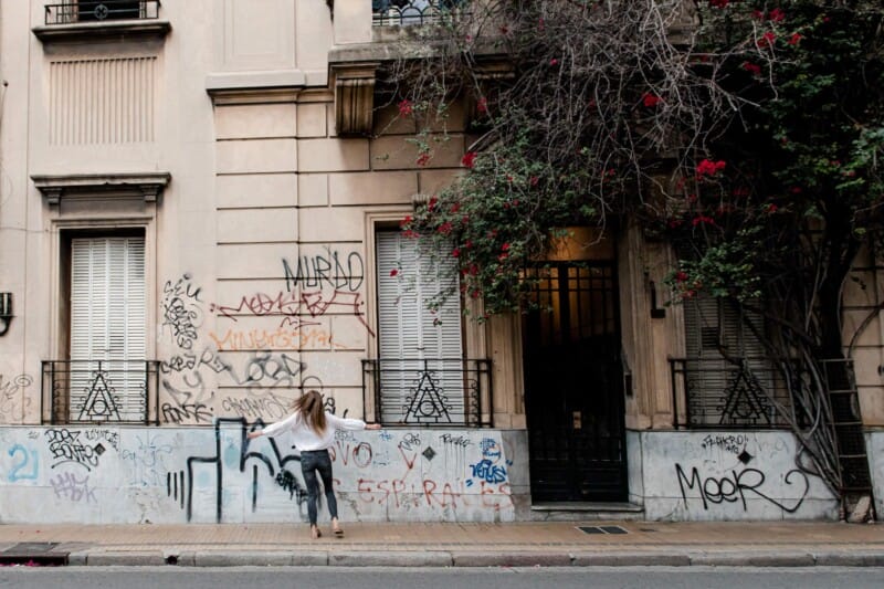 A woman twirls on the sidewalk