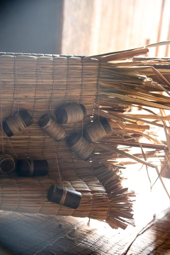 Bobbles of thread hang from a woven mat