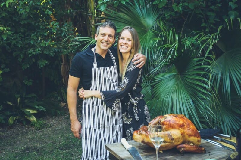 A man and woman pose in front of an enormous turkey