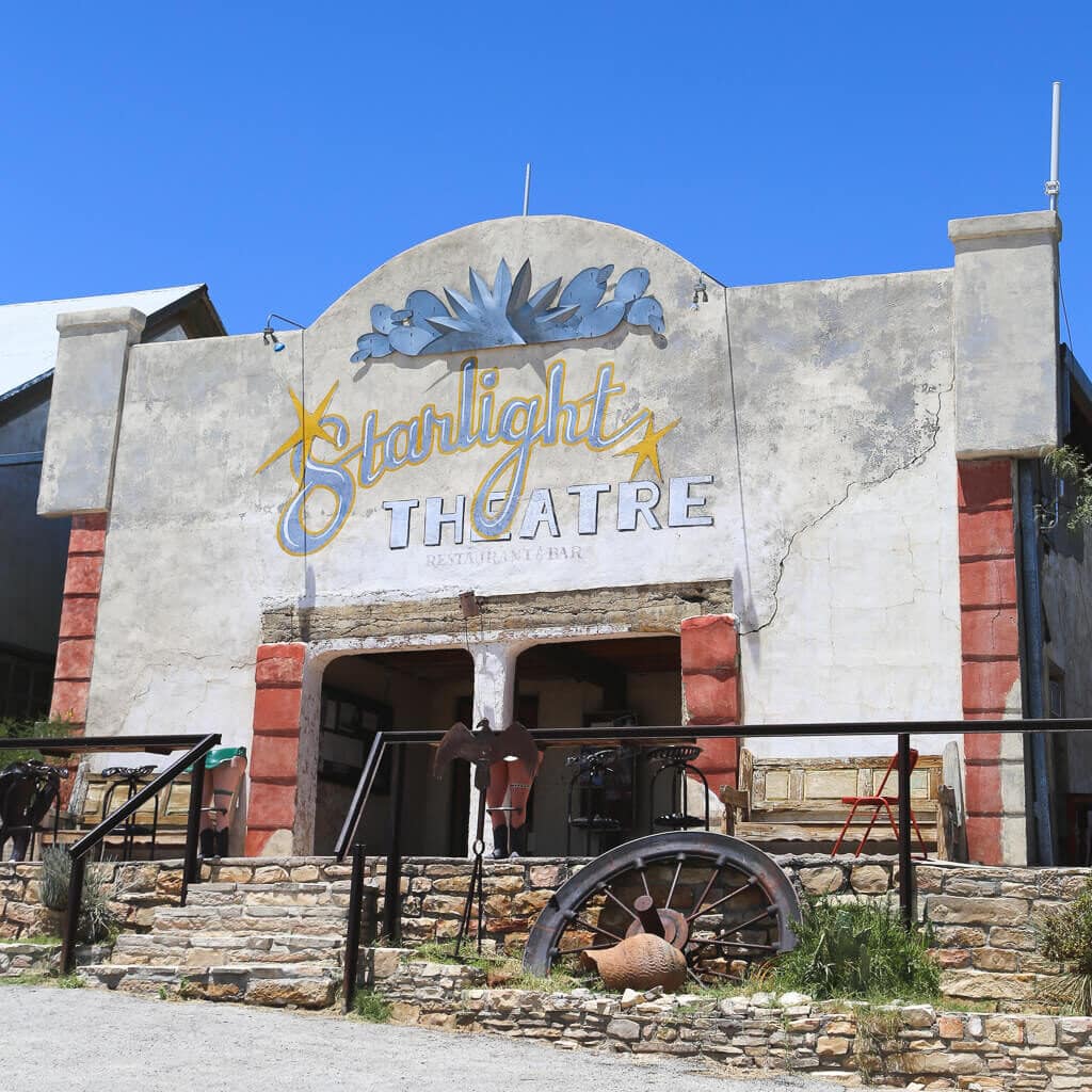 A theater with a porch and parking lot