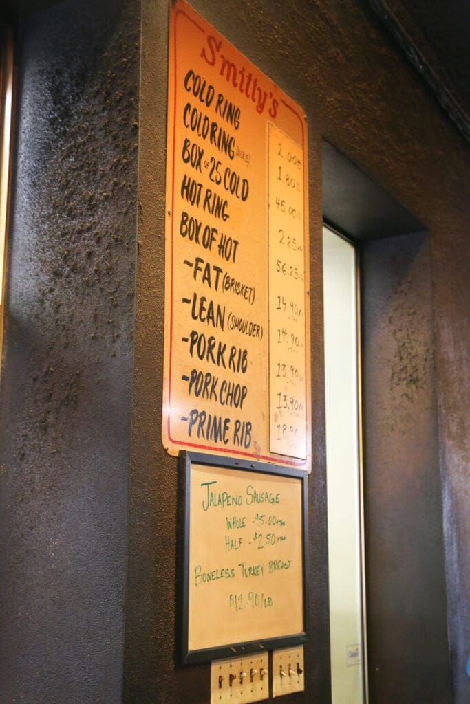 A BBQ menu hangs on a black wall