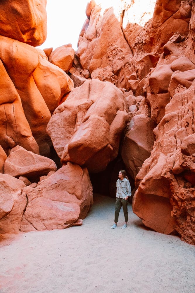 A woman standing in front of a cave