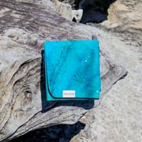 A blue yoga mat folded on a rock