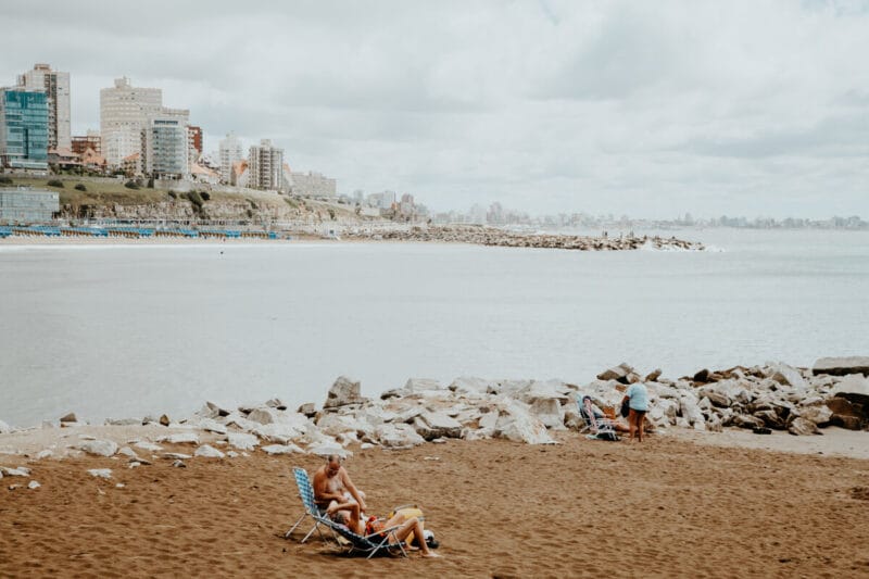 A man and woman lounge on beach chairs on the beach in Mar del Plata