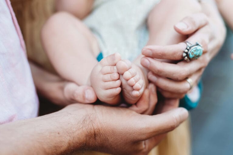 Two parents hold their baby's feet for a photo