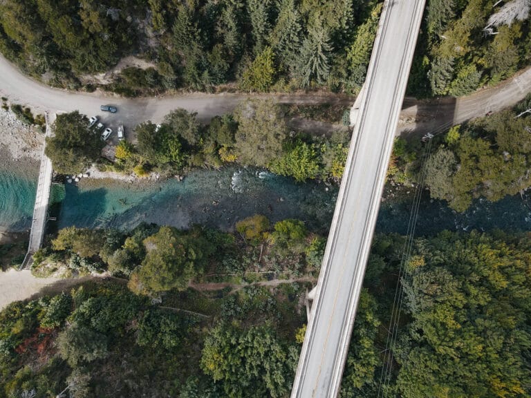 An aerial shot of a turquoise river with two bridges crossing it