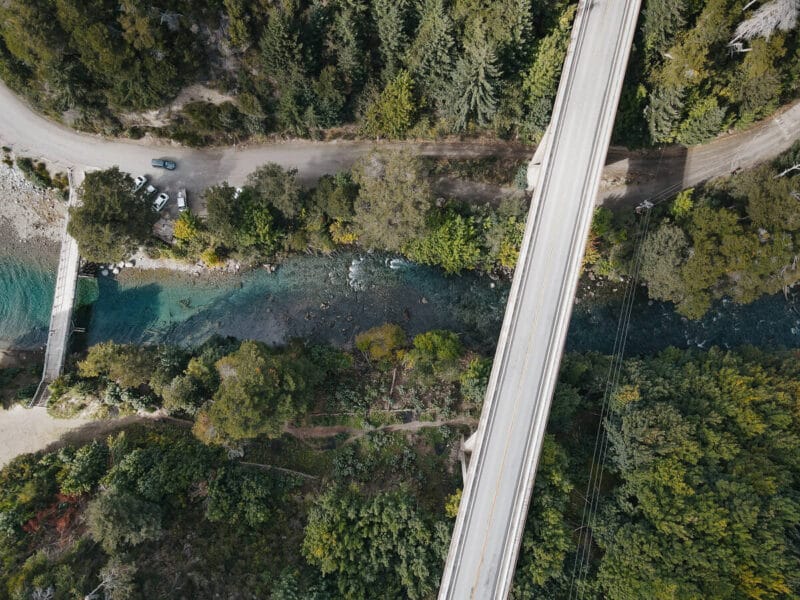 An aerial shot of a turquoise river with two bridges crossing it
