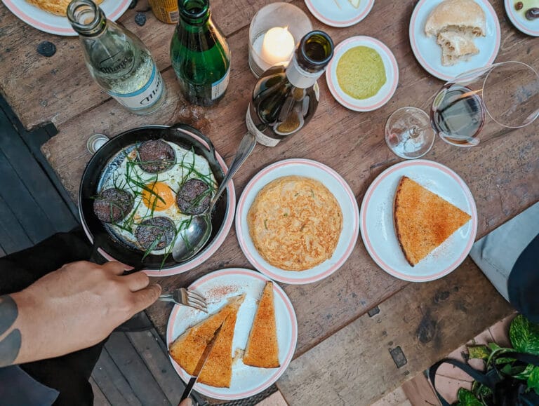 A spread of food seen from above on a wooden table in a Buenos Aires food tour