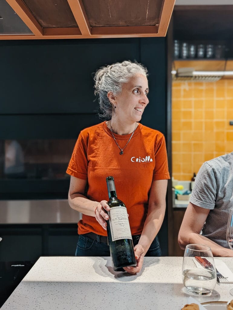 A sommelier displays a bottle of Malbec to an awaiting cooking class in Palermo Soho