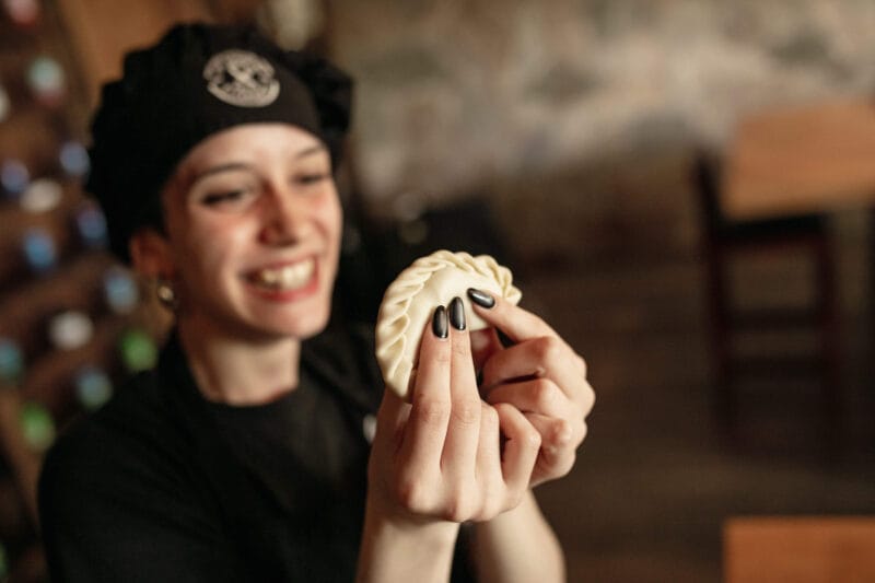 A woman closes an empanada at the Argentine Experience