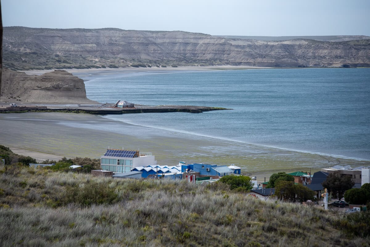 A view of Puerto Piramides from above with the beach and ocean in the background