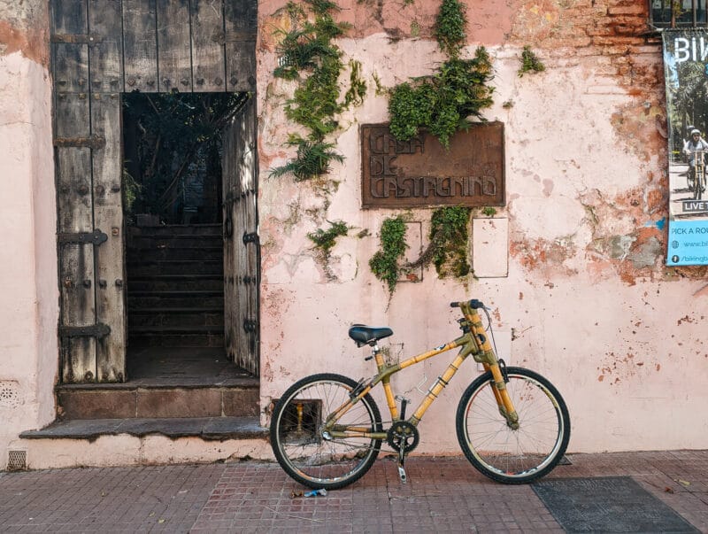 A bamboo bike is parked in front of a historic building that holds the best Buenos Aires bike tours office in San Telmo