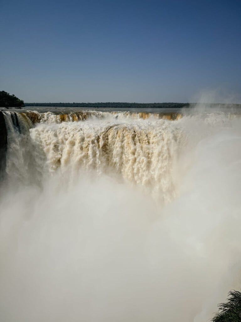The Devil's Throat waterfall pours down occupying the entire frame with mist rising up from the bottom