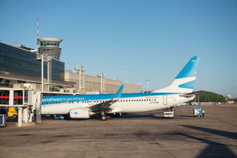 A bright blue and white airplanes is parked at the Ezeiza airport in Buenos Aires