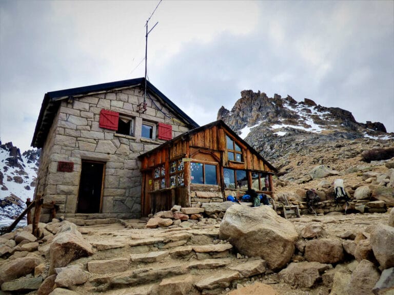 Stone stairs lead up to a building made out of stone and wood in the mountains of Bariloche